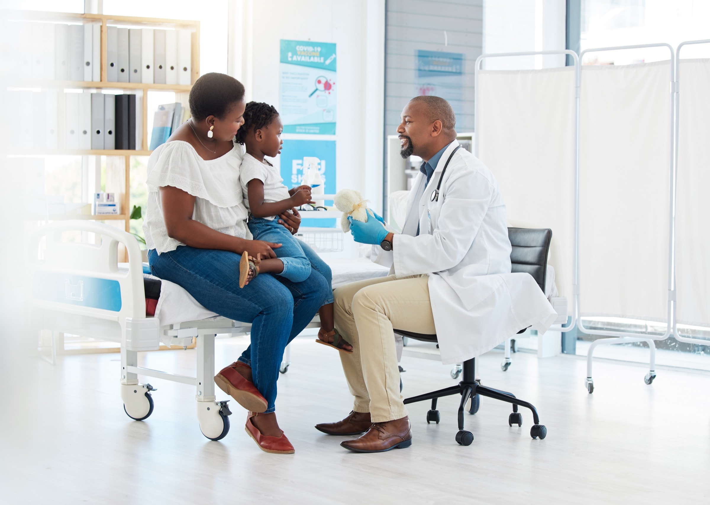 A child and parent with their doctor in a care setting